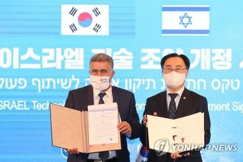 Industry Minister Moon Sung-wook (R) and his Israeli counterpart Amir Peretz after signing a bilateral agreement to expand ties in research and development projects and prepare for the post-pandemic era. (Yonhap)