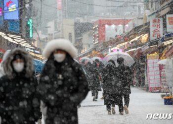 Citizens are walking in the snow near Hongdae, Mapo-gu, Seoul on the afternoon of the 18th, when the first heavy snow advisory of this winter was issued. 2021.12.18/News 1 © News1 Reporter Eun-na Ahn