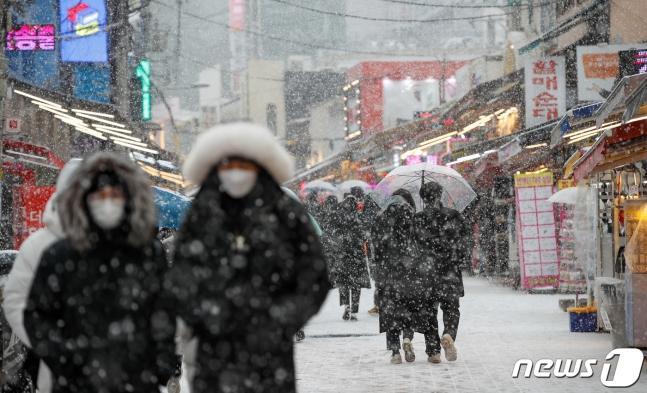 Citizens are walking in the snow near Hongdae, Mapo-gu, Seoul on the afternoon of the 18th, when the first heavy snow advisory of this winter was issued. 2021.12.18/News 1 © News1 Reporter Eun-na Ahn