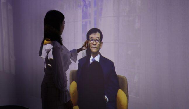 A woman is meeting an AI human at Deep Brain AI 's AI studio showroom
